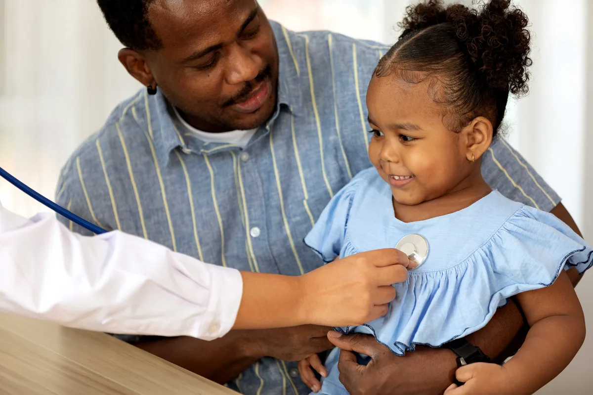A doctor gently examining a young child